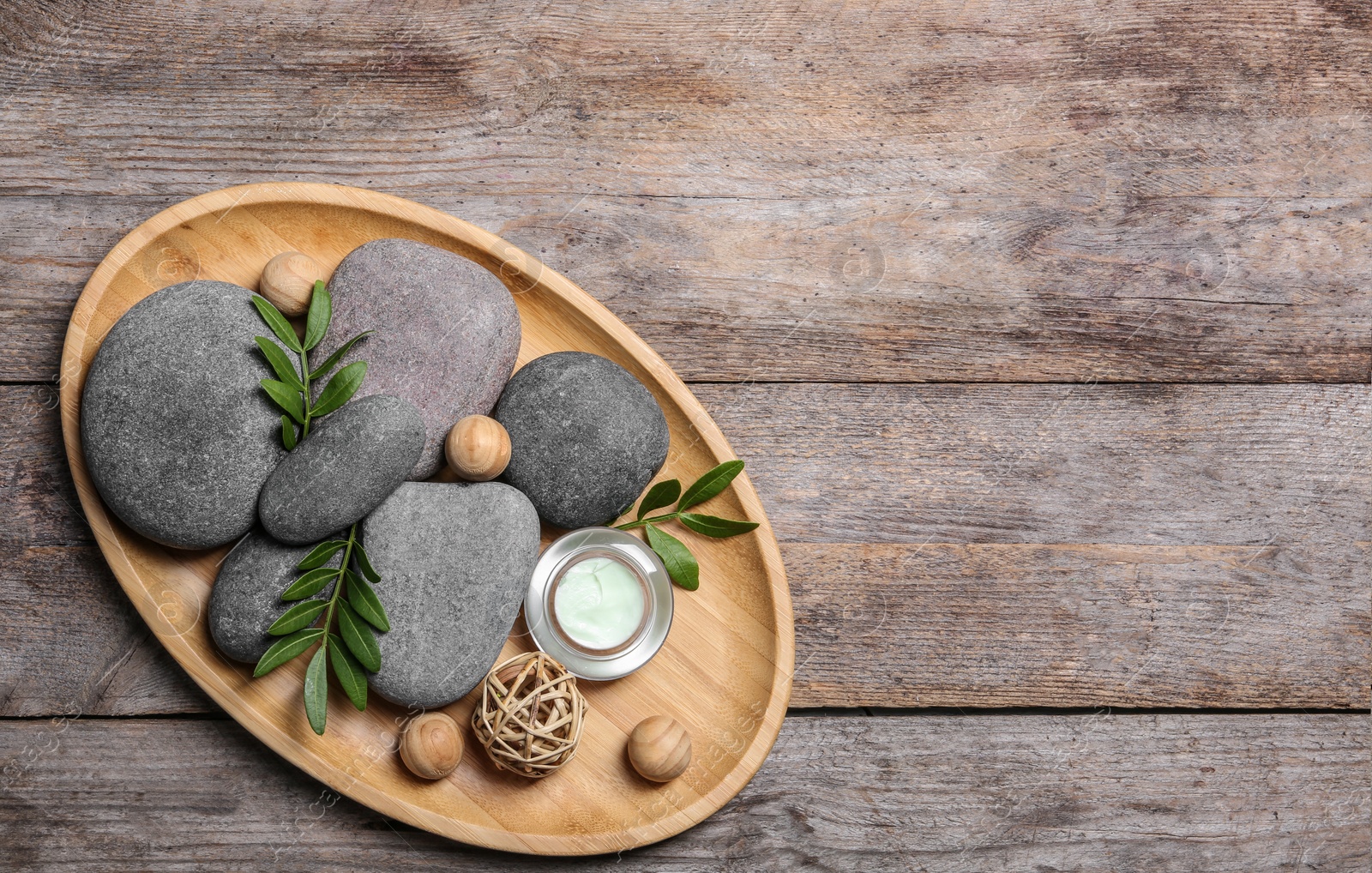 Photo of Composition with spa stones on wooden background, top view. Space for text
