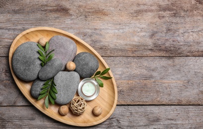 Photo of Composition with spa stones on wooden background, top view. Space for text