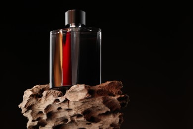 Luxury men`s perfume in bottle against dark background, space for text