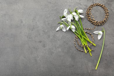 Photo of Beautiful snowdrops and twine on grey table, flat lay. Space for text