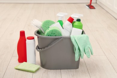 Photo of Different cleaning supplies in bucket on floor