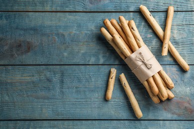 Photo of Delicious grissini sticks on wooden table, flat lay. Space for text