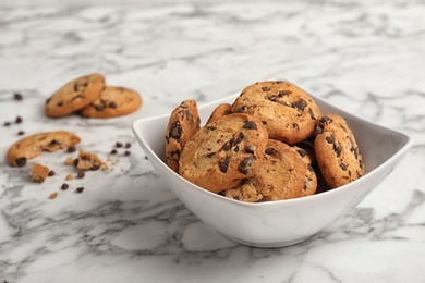 Bowl with chocolate chip cookies on marble background