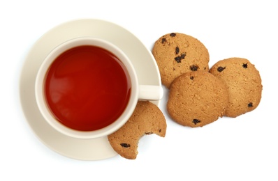 Ceramic cup of hot aromatic tea and tasty cookies on white background, top view