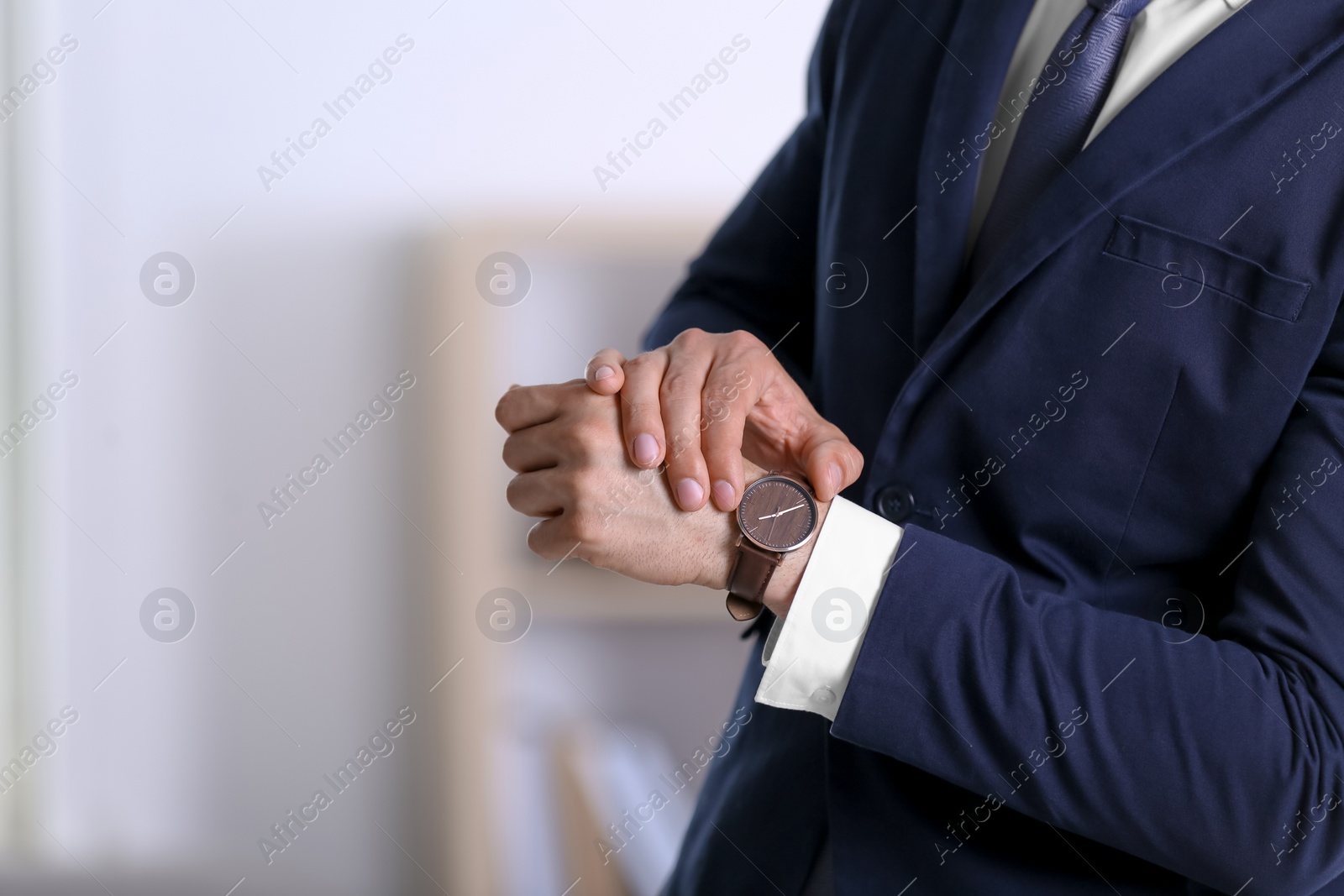 Photo of Businessman with wristwatch on blurred background, Time concept