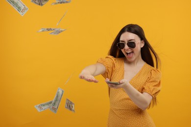 Photo of Happy woman throwing money on orange background