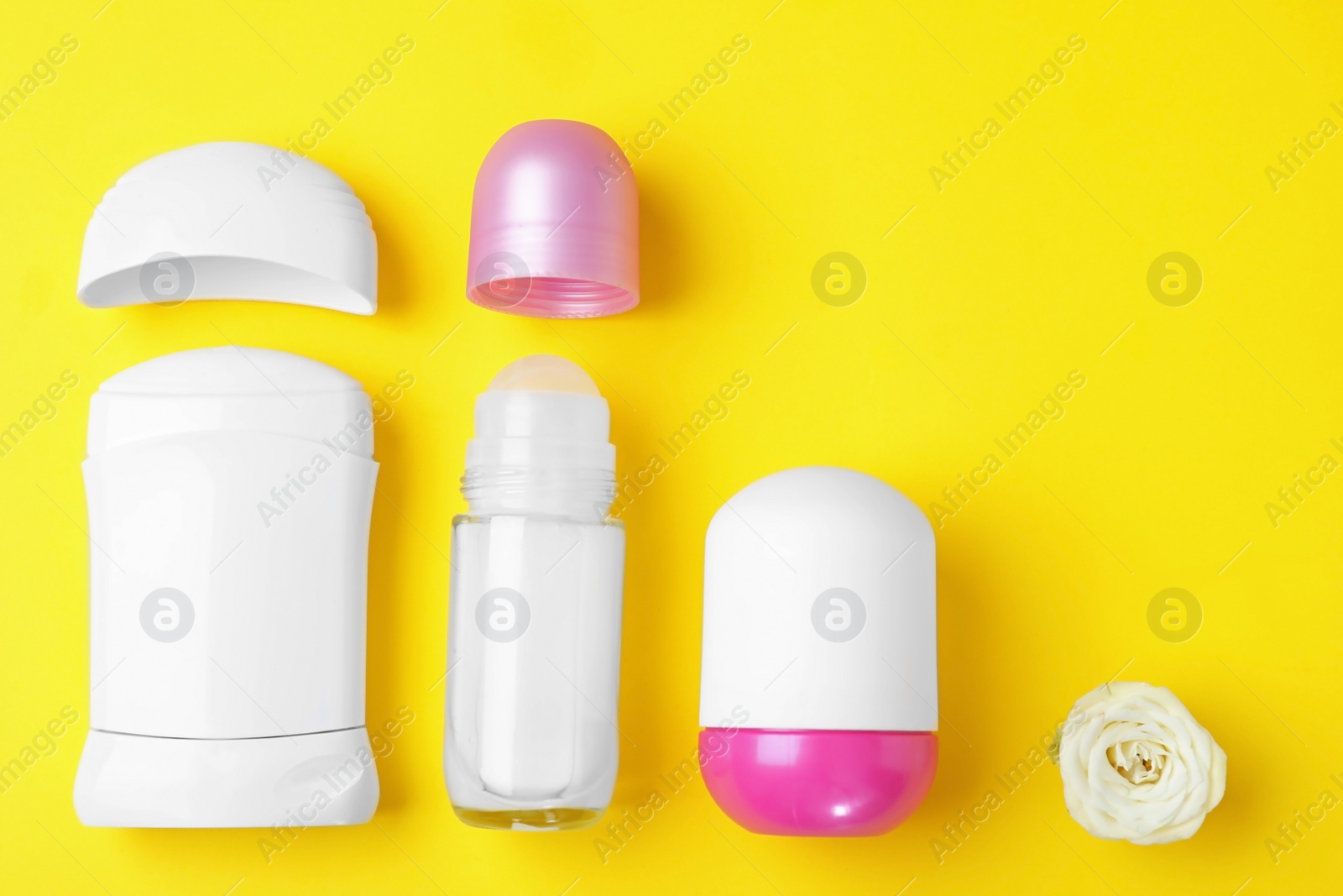 Photo of Flat lay composition with different female deodorants on yellow background, space for text
