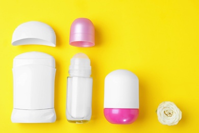 Flat lay composition with different female deodorants on yellow background, space for text