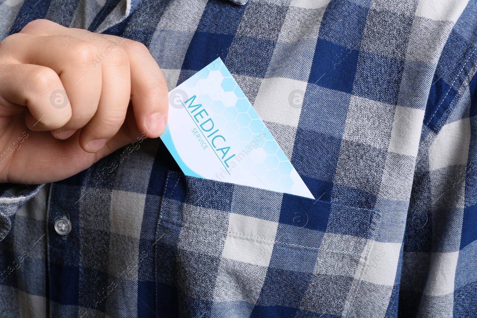 Photo of Man putting business card into pocket, closeup. Medical service