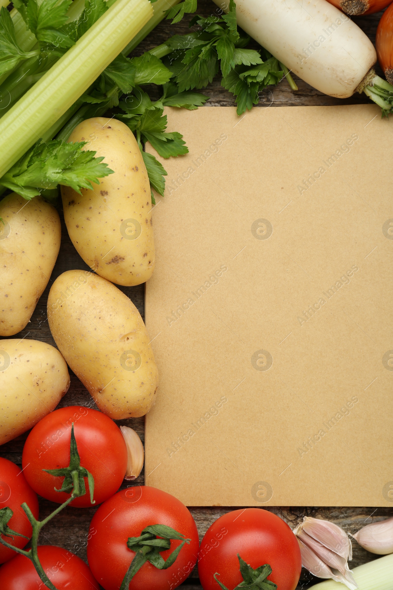 Photo of Blank recipe book and different ingredients on wooden table, flat lay. Space for text