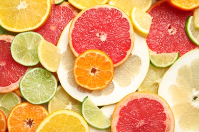 Different citrus fruits as background, top view