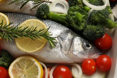 Photo of Raw fish with vegetables and lemon in baking dish