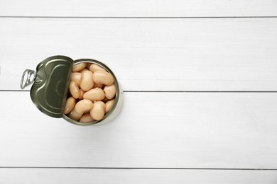 Photo of Tin can of canned kidney beans on white wooden table, top view. Space for text