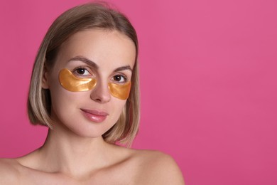 Photo of Beautiful young woman with under eye patches on pink background, space for text