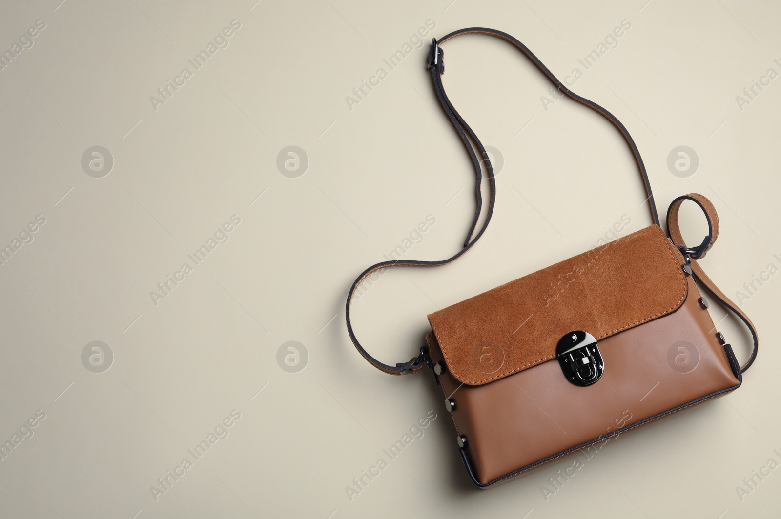 Photo of Stylish woman's bag on beige background, top view. Space for text