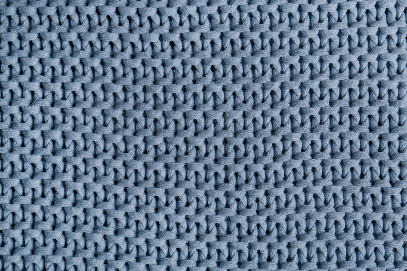 Photo of Beautiful light blue knitted fabric as background, top view