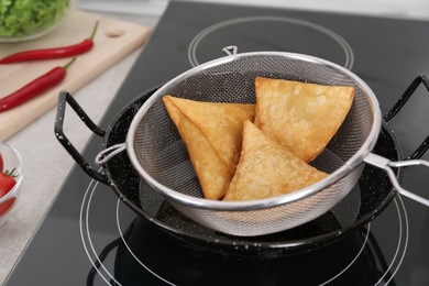 Photo of Heating up samosas on electric stove, closeup