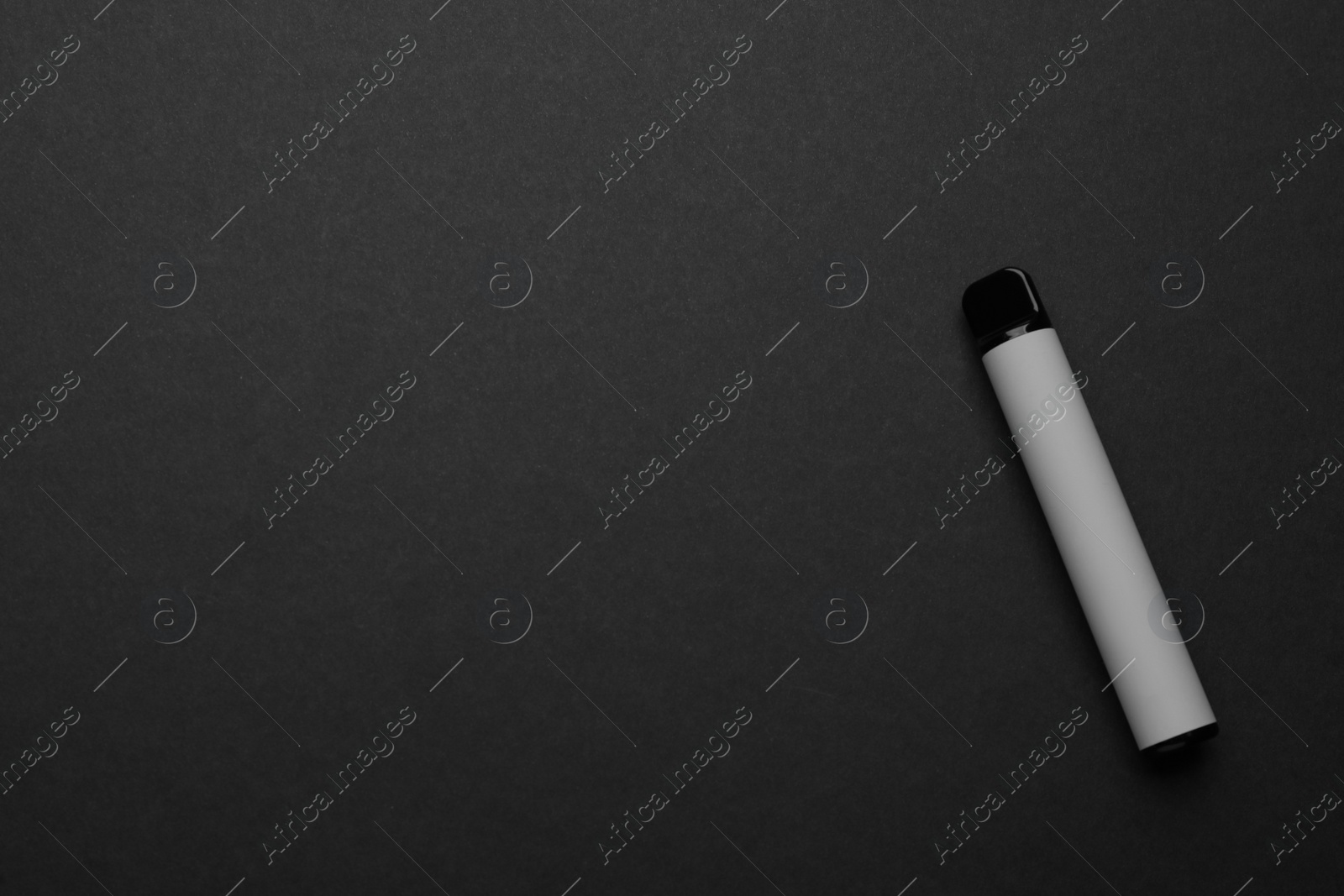 Photo of Disposable electronic smoking device on black background, top view. Space for text