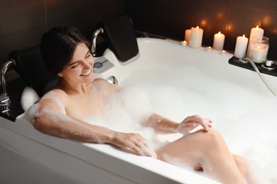 Photo of Happy beautiful woman taking bubble bath. Romantic atmosphere