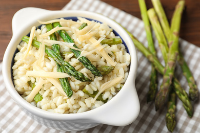 Delicious risotto with asparagus served on table, closeup