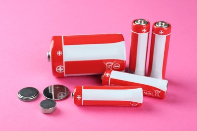 Different types of batteries on pink background