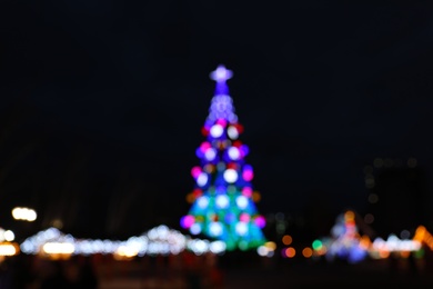 Photo of Beautiful decorated Christmas tree outdoors. Bokeh effect