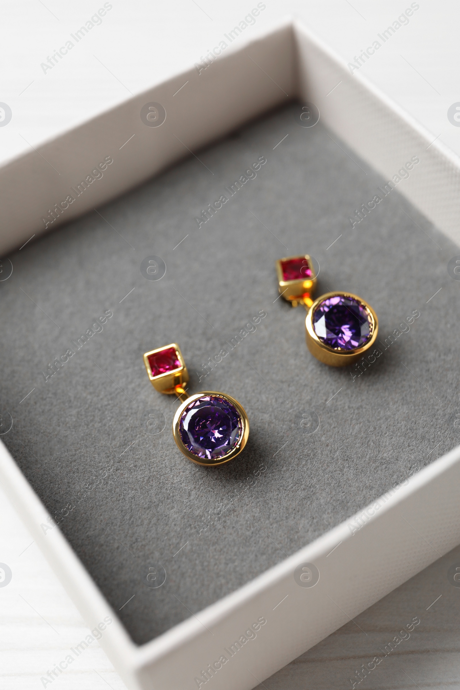 Photo of Earrings in jewel box on white table, closeup