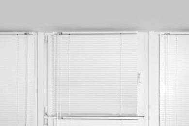 Photo of Window with closed white horizontal blinds indoors, low angle view