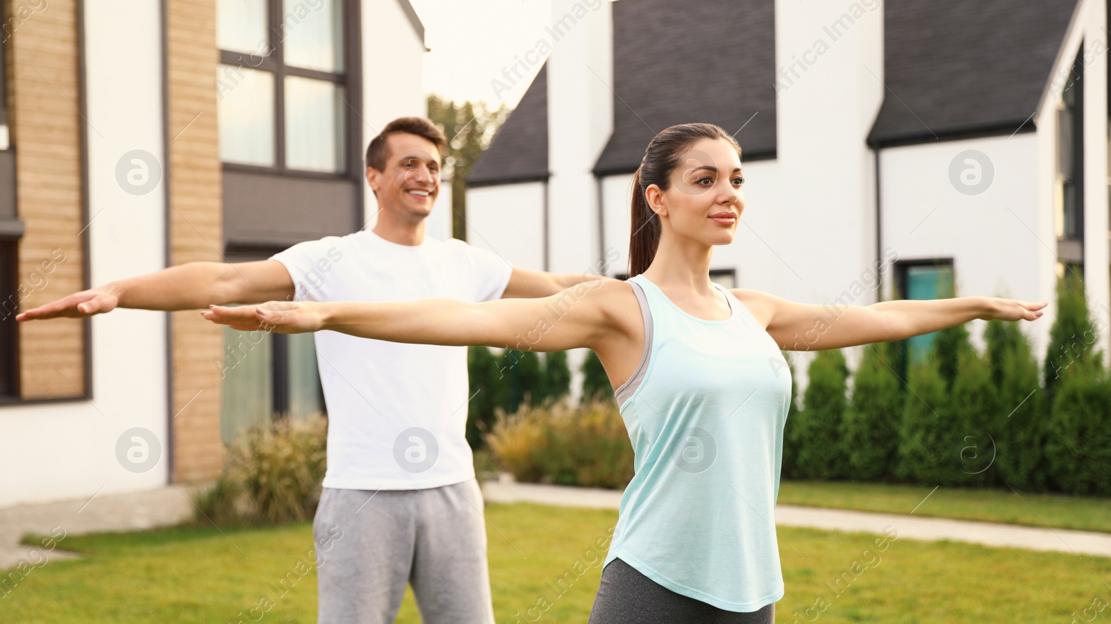 Photo of Sporty couple doing exercise on backyard. Healthy lifestyle