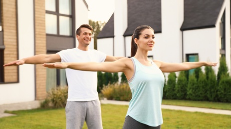 Sporty couple doing exercise on backyard. Healthy lifestyle