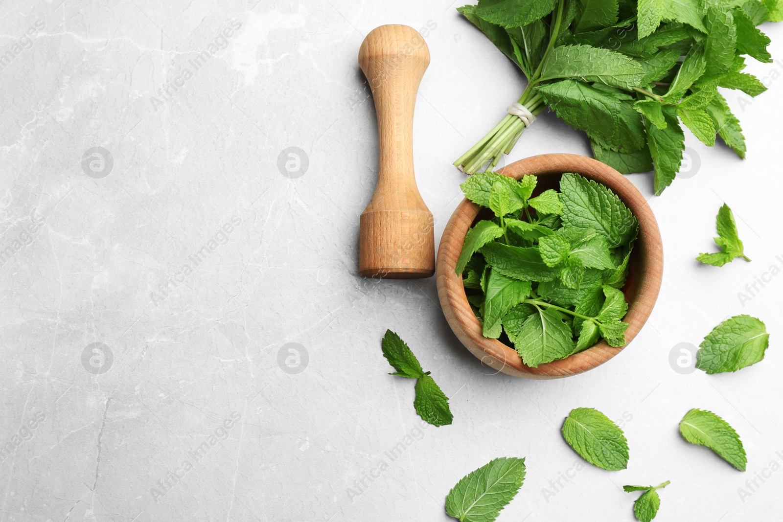 Photo of Fresh mint with mortar and pestle on grey marble background, flat lay. Space for text