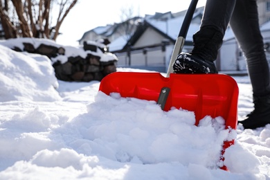 Photo of Person shoveling snow outdoors on winter day, closeup