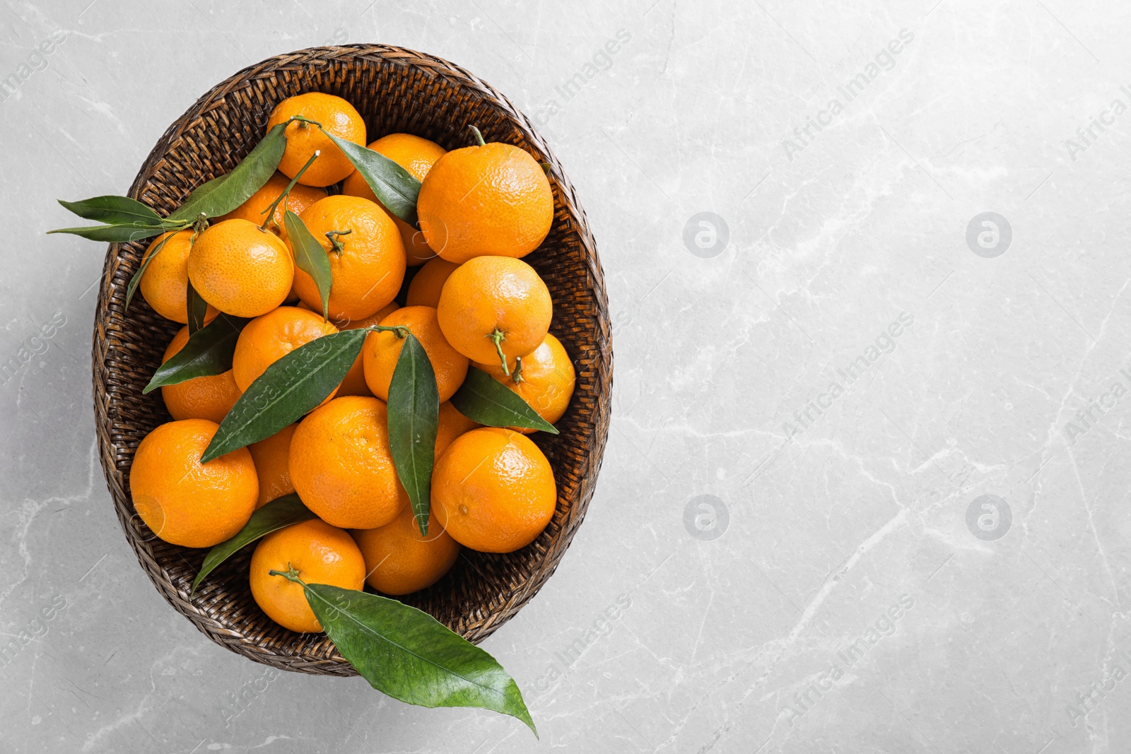 Photo of Fresh ripe tangerines on marble table, top view. Space for text