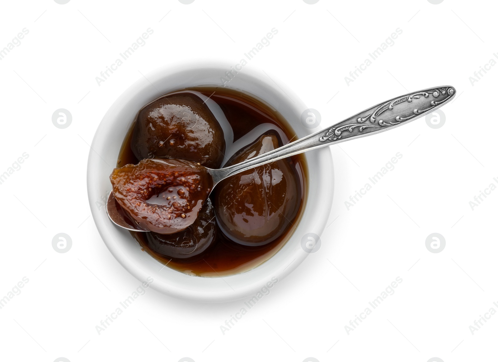 Photo of Bowl of tasty sweet fig jam and spoon isolated on white, top view