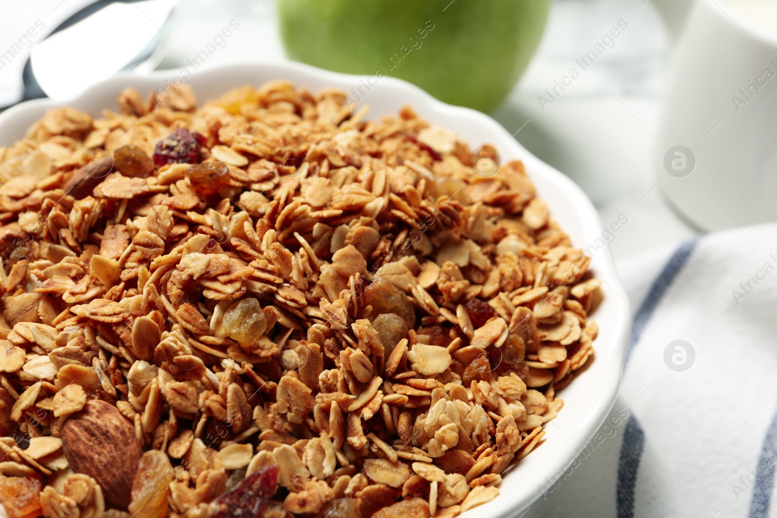 Photo of Tasty muesli with raisins on table, closeup. Healthy breakfast