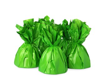 Delicious candies in green wrappers on white background