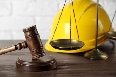 Labour, construction and land law concepts. Judge gavel, scales of justice with protective helmet on wooden table