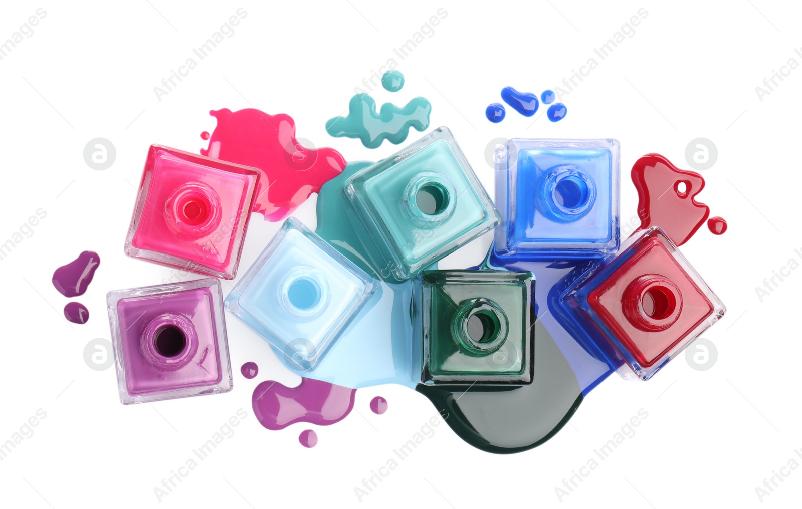 Photo of Drops of different bright nail polishes and bottles isolated on white, top view