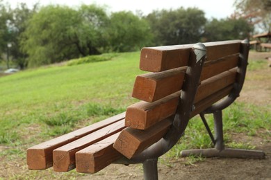 Photo of Stylish wooden bench in park on sunny day, closeup