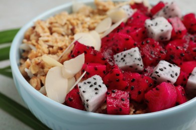 Photo of Granola with pitahaya and almond petals in ceramic bowl, closeup