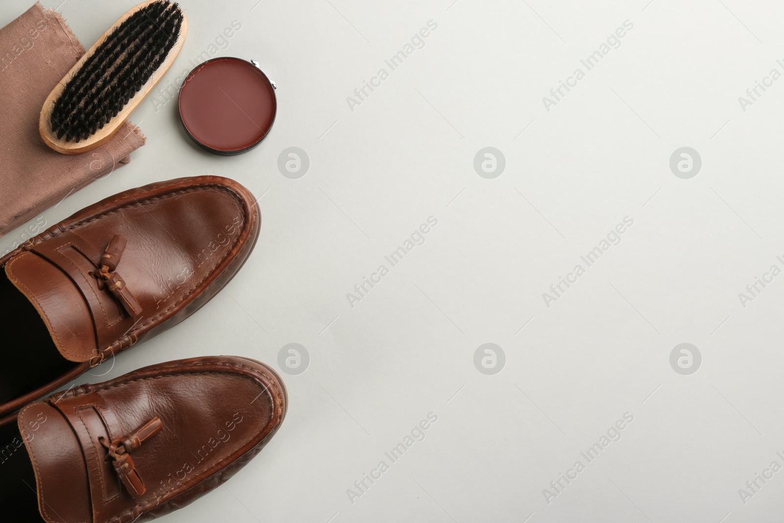 Photo of Flat lay composition with shoe care accessories and footwear on light grey background. Space for text
