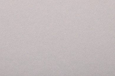 Photo of Texture of light grey paper sheet as background, top view