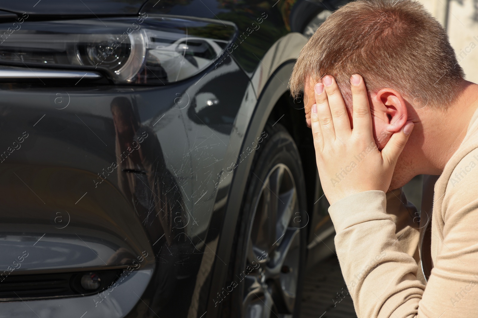 Photo of Stressed man near car with scratch outdoors