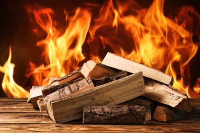 Image of Dry wood and burning fire on background. Cozy atmosphere