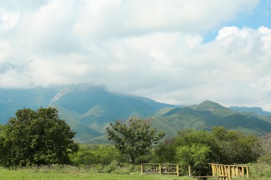 Photo of Picturesque view of mountains and green meadow