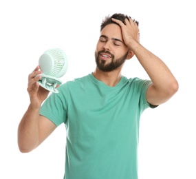 Man enjoying air flow from portable fan on white background. Summer heat