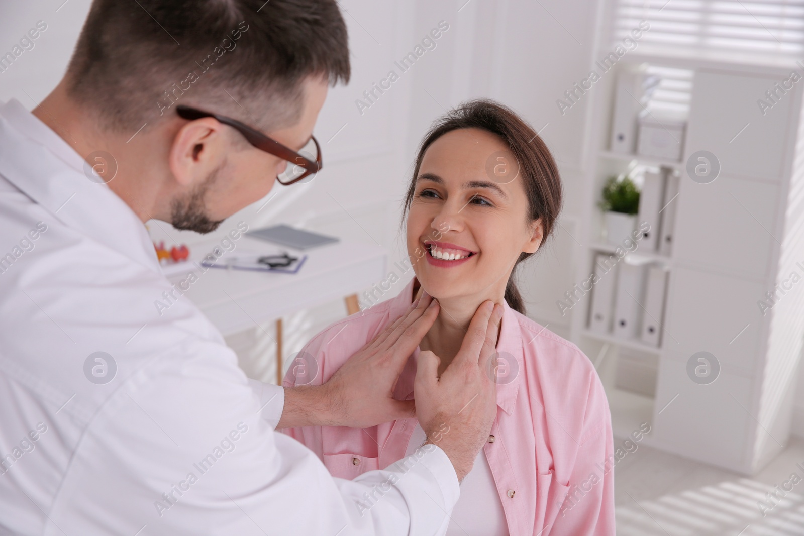 Photo of Doctor examining thyroid gland of patient in hospital