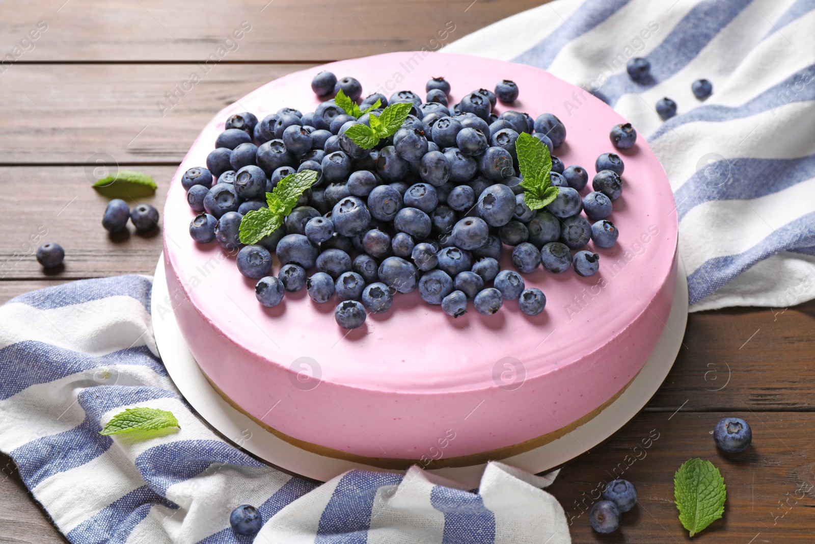 Photo of Tasty blueberry cake and napkin on wooden table