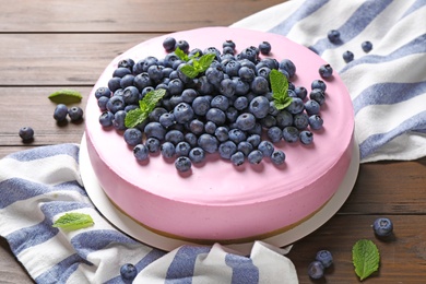 Photo of Tasty blueberry cake and napkin on wooden table