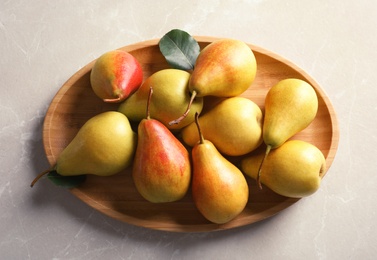 Photo of Plate with ripe pears on light background